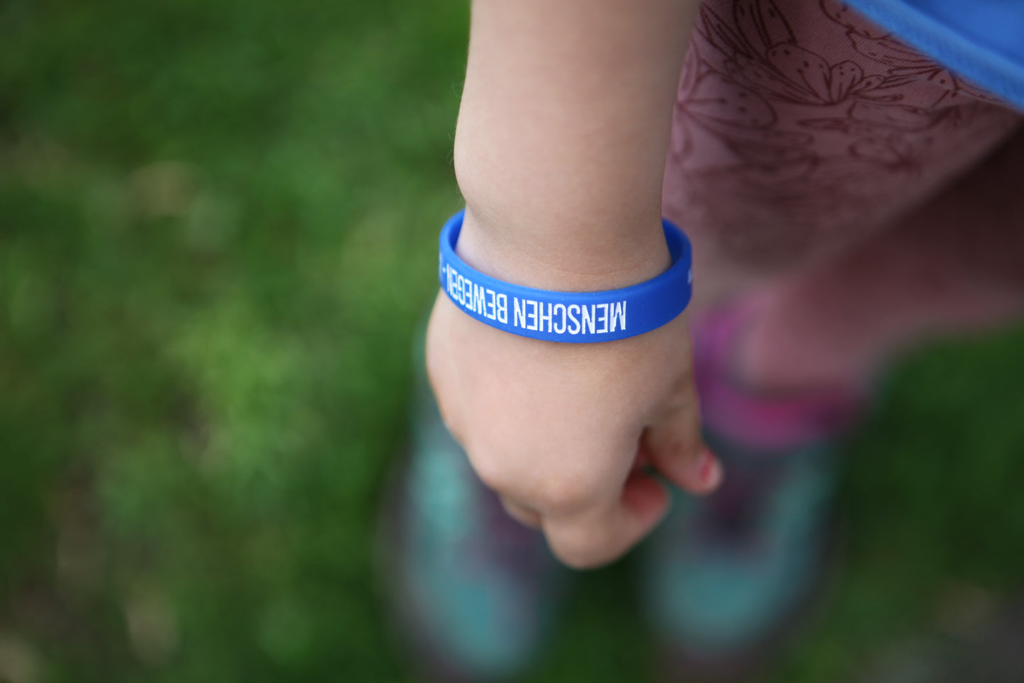 Blaues Gummiarmband – „Menschen bewegen. Welt verändern.“