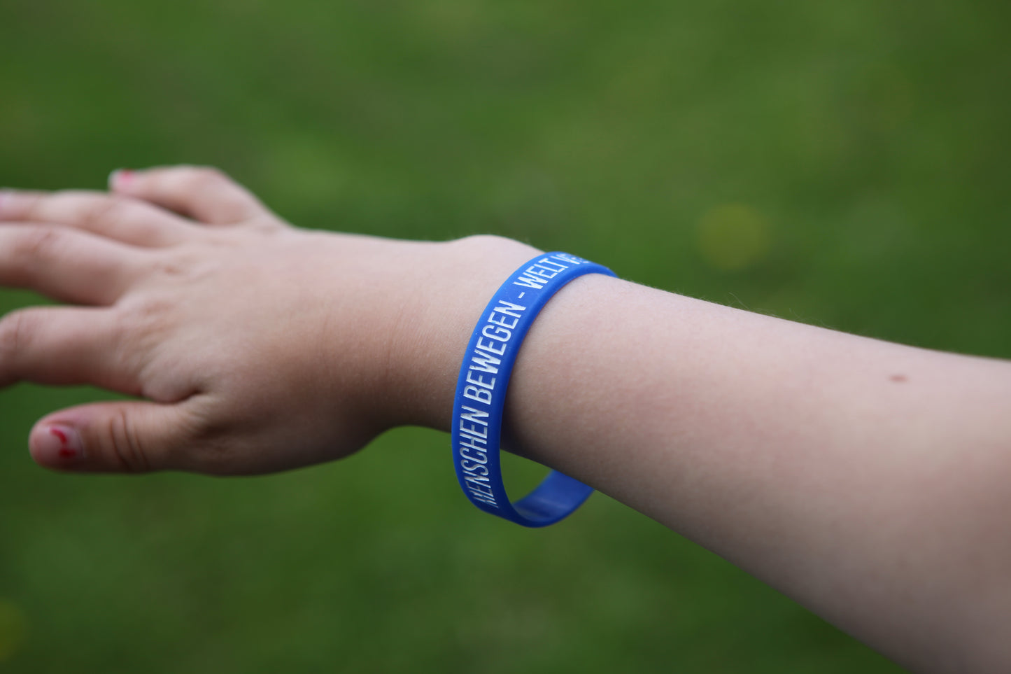 Blaues Gummiarmband – „Menschen bewegen. Welt verändern.“