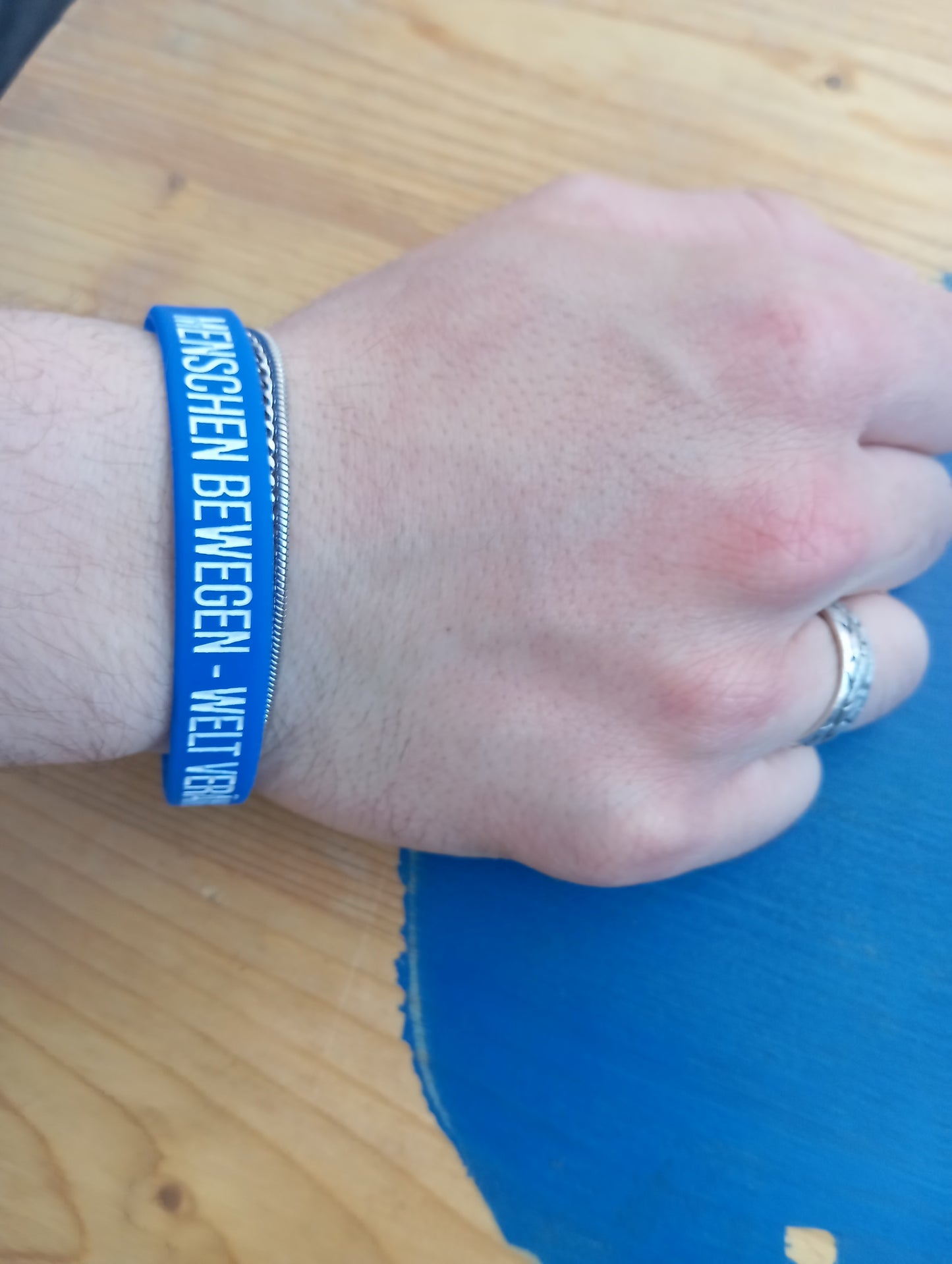 Blaues Gummiarmband – „Menschen bewegen. Welt verändern.“